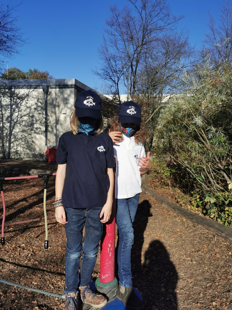 Zwei Kinder tragen Poloshirts.